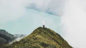 1366x768 Man On Mountain Peak Travel Background
