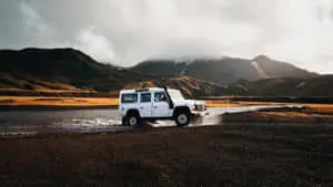 1366x768 White Land Rover Near River Travel Background