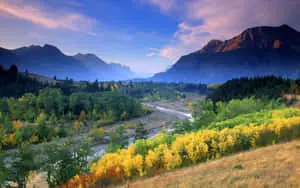 A picturesque view of rolling hills and lush trees against a tranquil blue sky