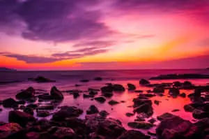 a sunset with rocks and a sunset