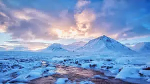 A stunning view of a lake surrounded by majestic snow-capped mountains