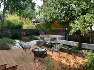 a backyard with a wooden deck and a wooden table