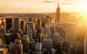a cityscape with buildings and a sun setting